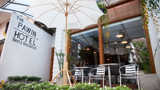 The Pawin Hotel with outdoor seating and a large umbrella. - The Pawin (Chiang Mai)