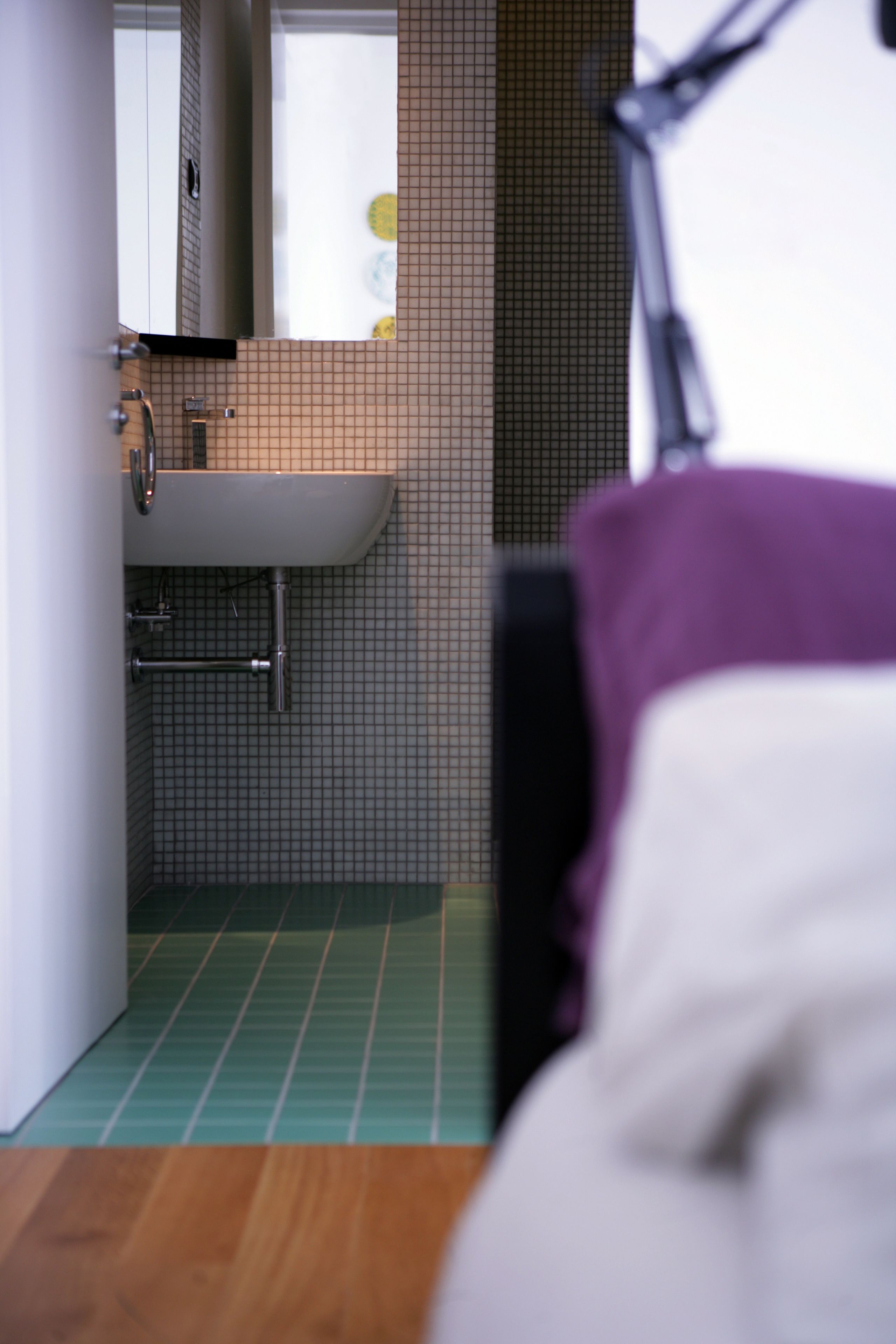 Een badkamer met een wastafel, spiegel en betegelde wanden.