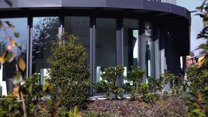 Un edificio moderno con fachada curva, ventanas amplias y un diseño geométrico único.