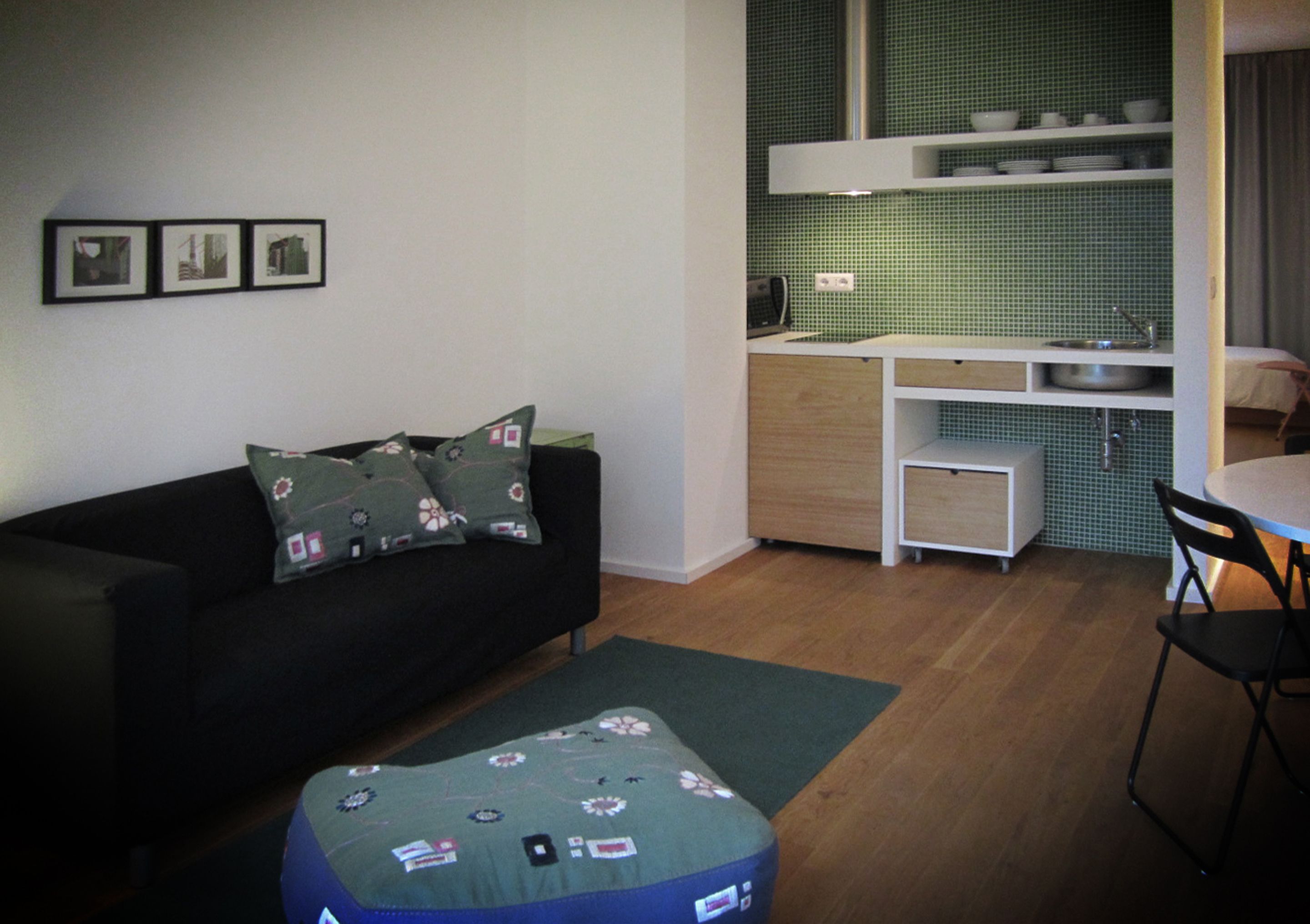 A compact living space with a sofa, a small dining table, and a kitchenette.