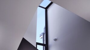 Una escalera moderna con diseño geométrico y tragaluz.
