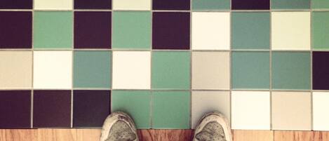 A tiled floor with a pattern of green, white, and black squares.