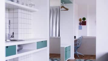 Ein modernes Badezimmer mit weißen Fliesen, einem Waschbecken und einem Spiegel. Der Boden ist mit einem Muster versehen und im Hintergrund steht ein Stuhl.