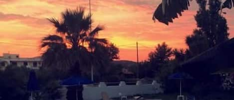 Una piscina al aire libre de temporada, sombrillas, tumbonas