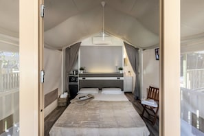 Een gezellige slaapkamer met een bed, nachtkastje en een klein bureau met stoel.
