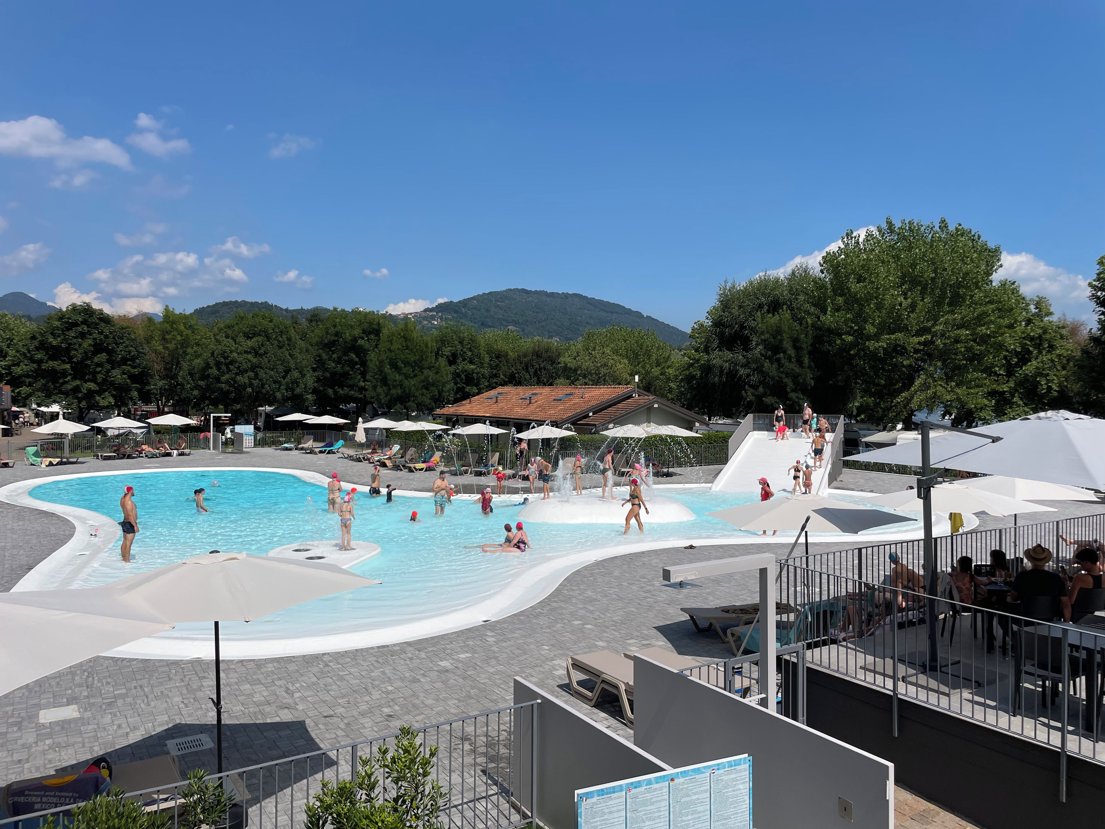 Un espace piscine doté d’un toboggan et de chaises longues.