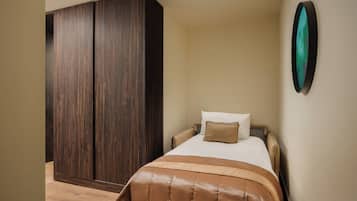 Une chambre à coucher comprenant un lit, une armoire et une œuvre d’art accrochée au mur.