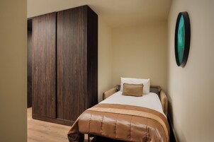 Une chambre à coucher comprenant un lit, une armoire et une œuvre d’art accrochée au mur.
