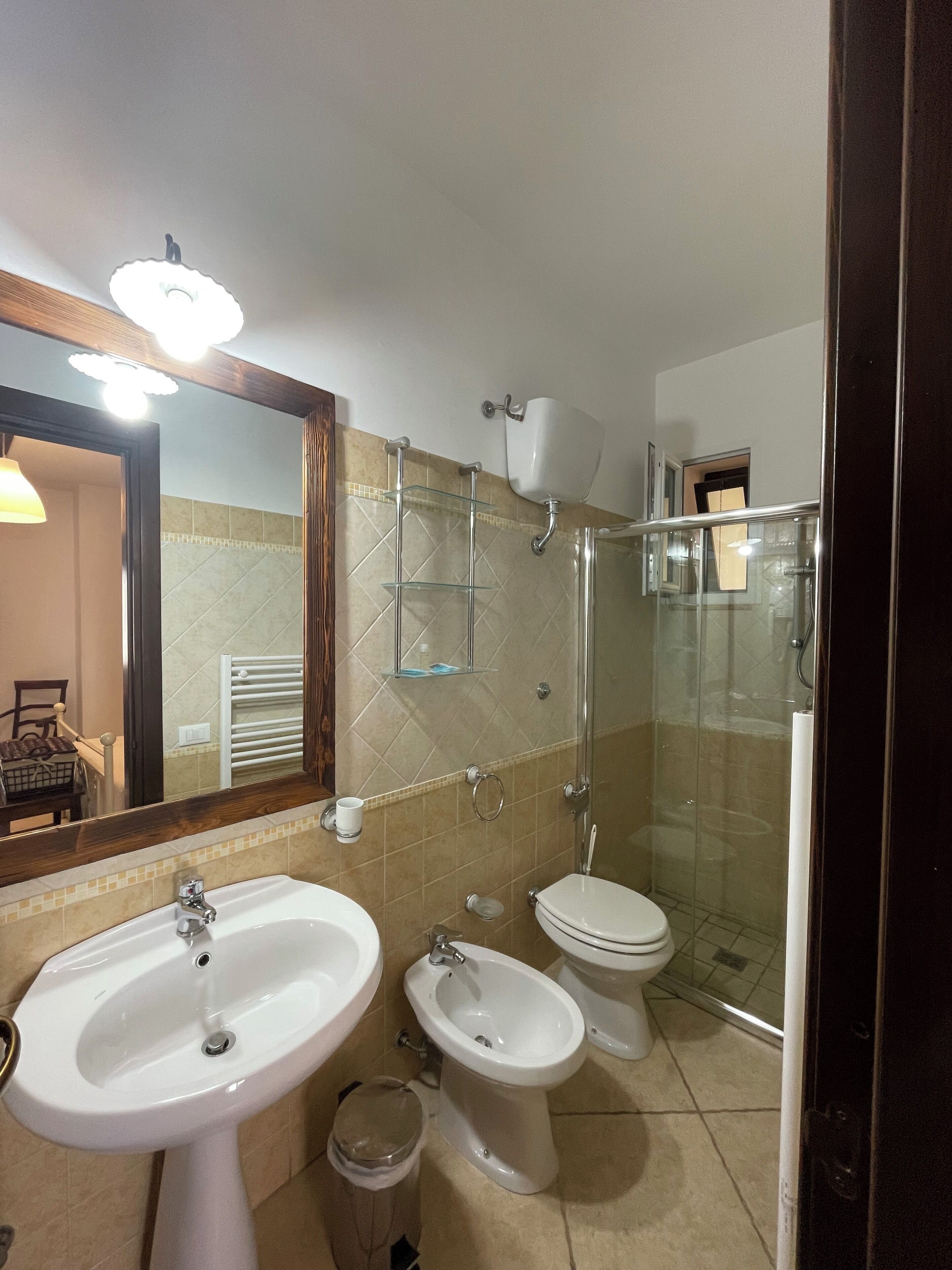 Une salle de bain équipée d’un lavabo, d’un bidet, de toilettes et d’une douche à parois en verre.