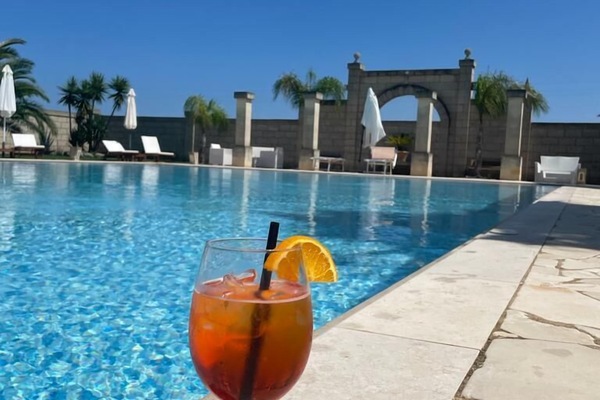 Alberca al aire libre, sombrillas en la alberca y camastros