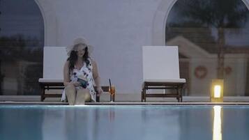 Un espace aménagé au bord de la piscine, avec des chaises longues et des boissons.