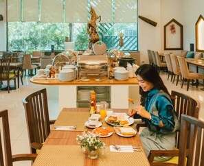 Un comedor con mesas de buffet, incluyendo platos, tazones y una variedad de alimentos.