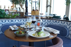 Una mesa de comedor con platos de comida, vasos y una botella.