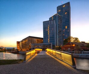 A modern building with a glass facade and a bridge leading to it. - Clarion Hotel Malmö Live (Malmö)
