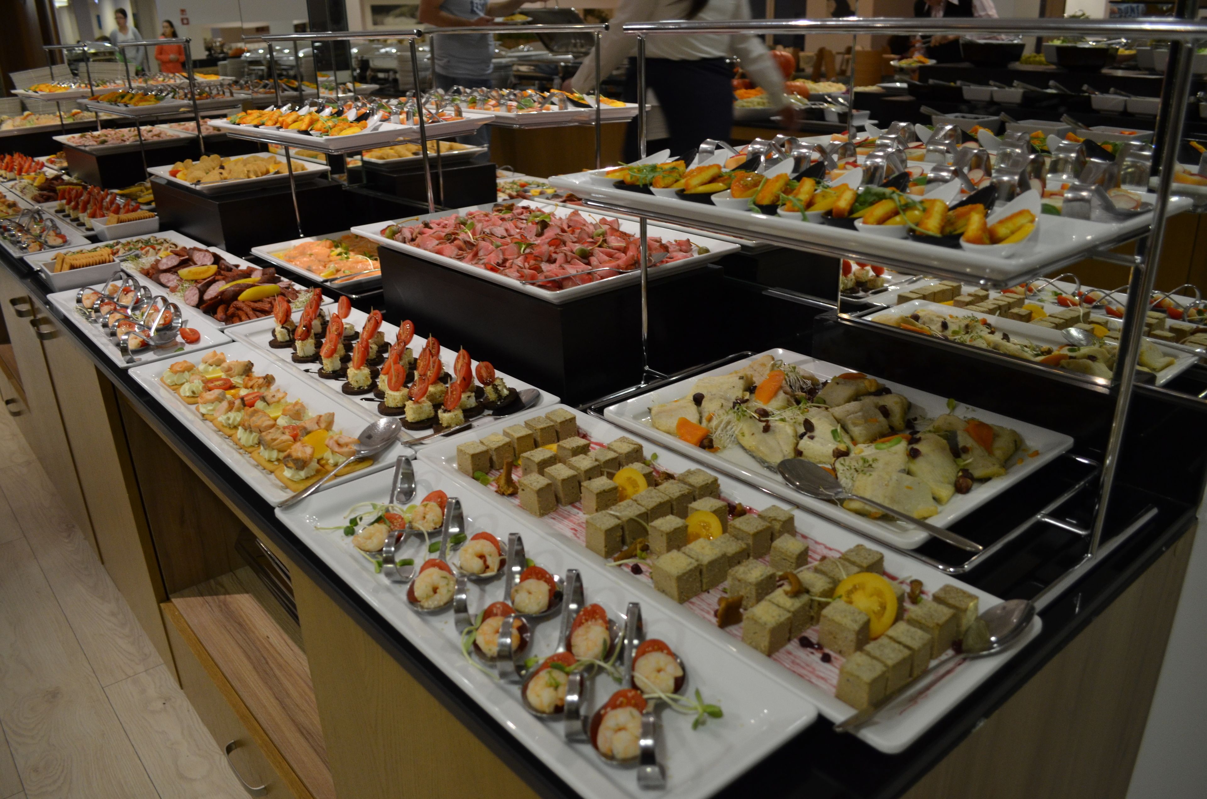 A buffet with various food items and utensils.