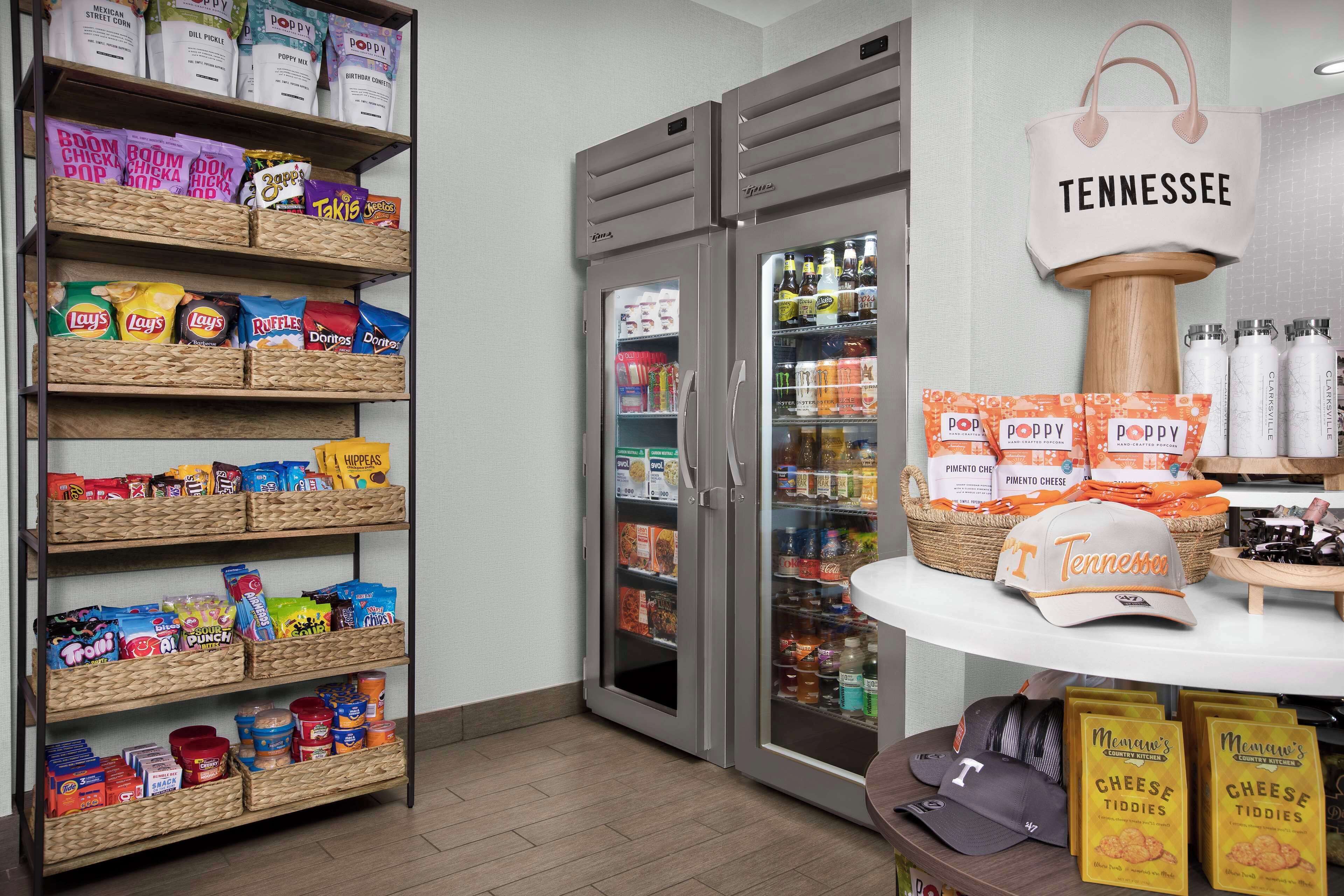 A snack display with various chips and snacks, a refrigerated section with beverages, and a Tennessee-themed display with cheese tiddies.