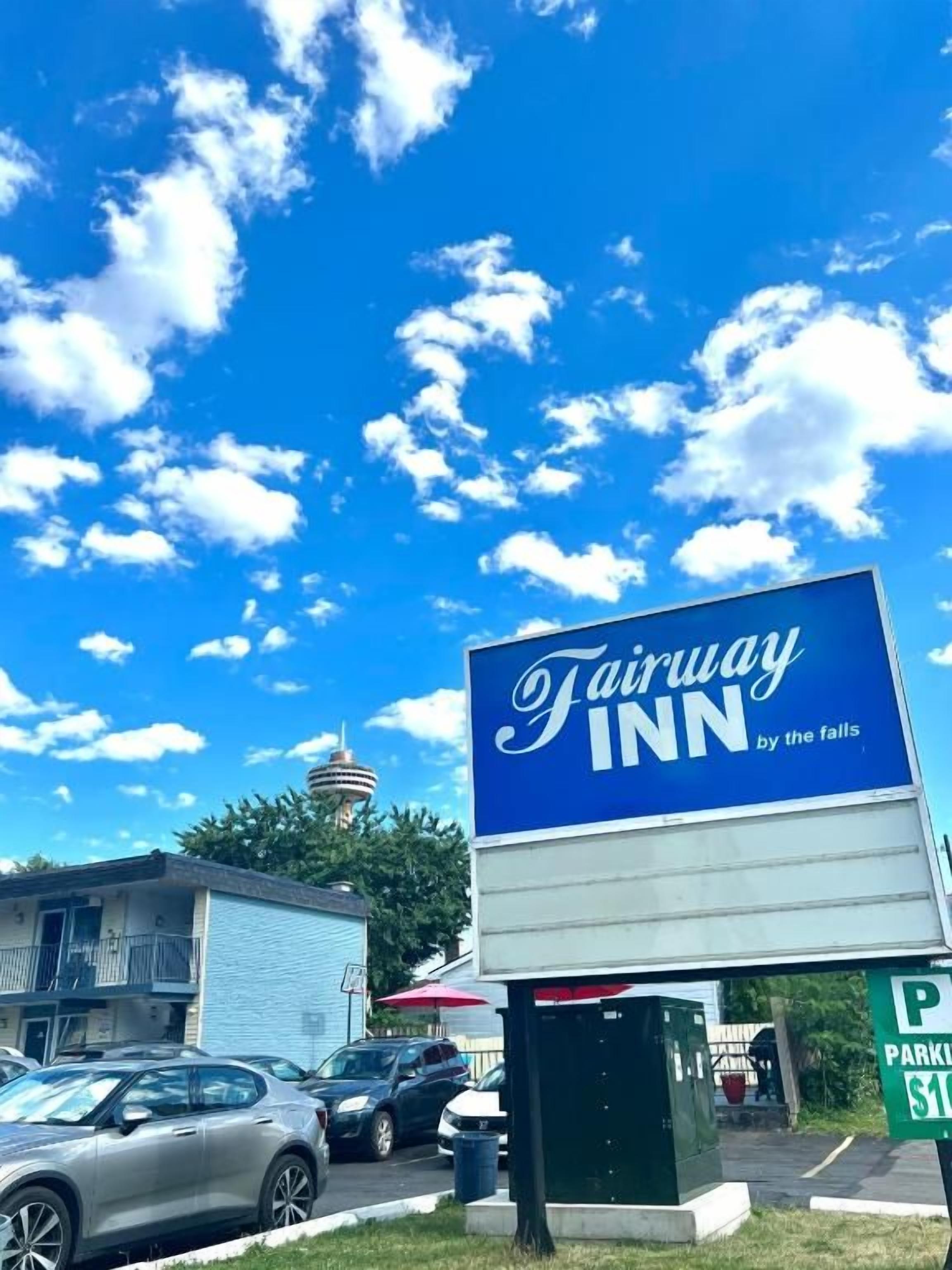 Cartel de Fairway Inn junto a las cataratas, con un letrero de estacionamiento que indica $11.