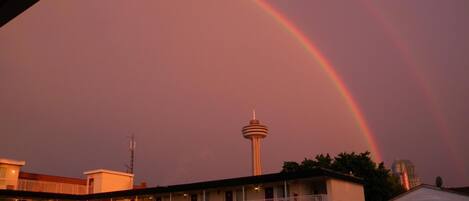 A motel with a two-story structure, a central tower, and a visible rainbow.