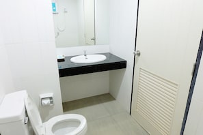 A bathroom with a toilet, sink, mirror, and shower. - Krabi Hipster Hotel (Krabi)