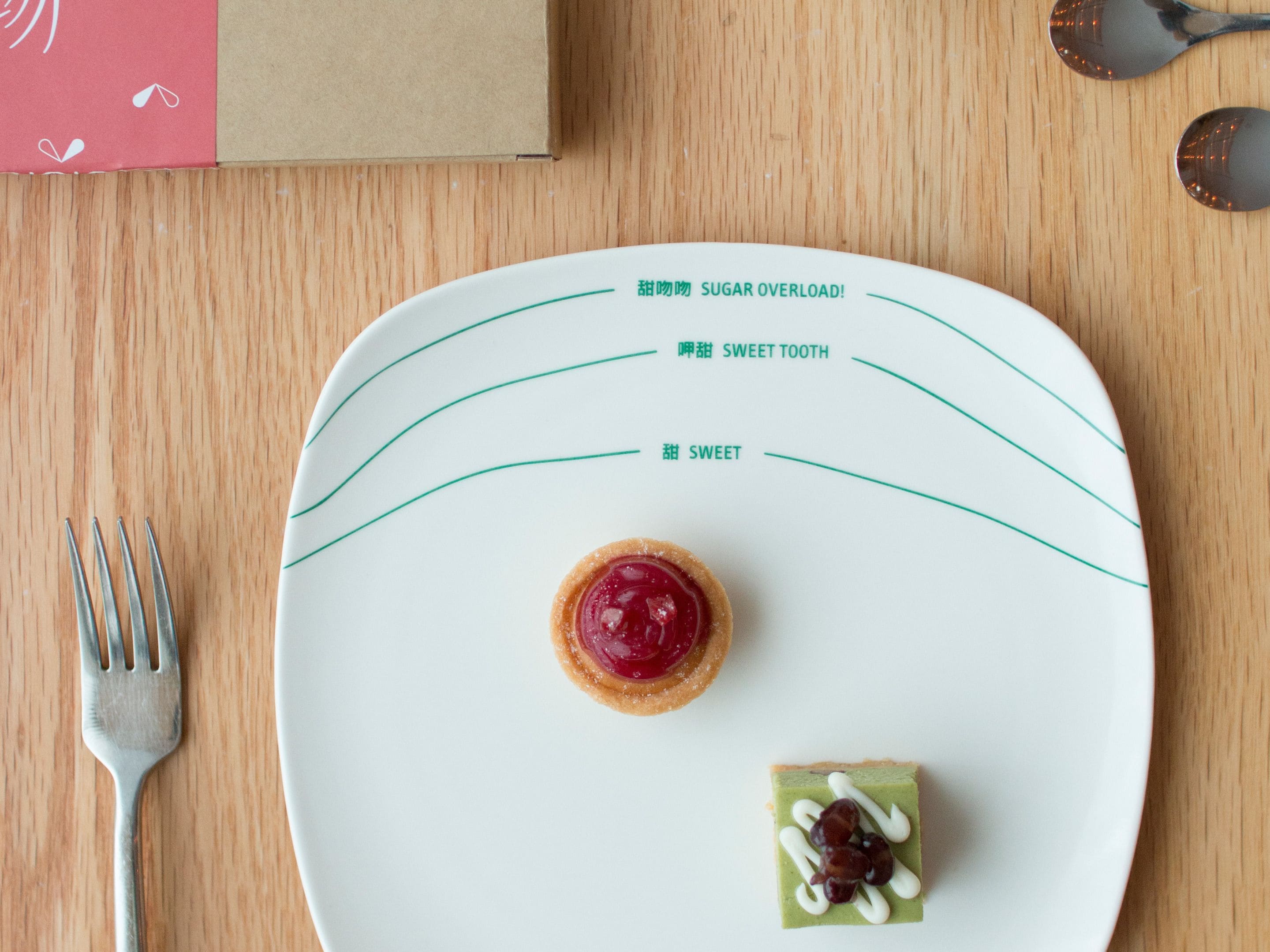 Un plato con dos postres y un tenedor sobre una mesa de madera.