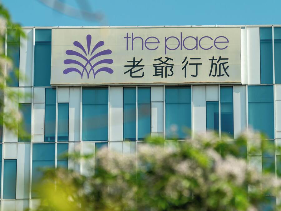 Un edificio con un letrero que dice “the place” y caracteres chinos.