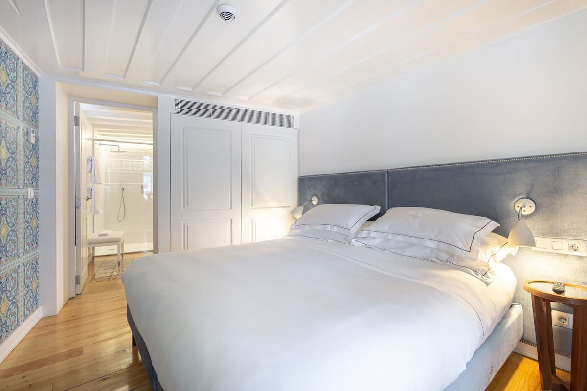 Ein Schlafzimmer mit einem großen Bett, einem Nachttisch, einem Kopfteil und einer Duschkabine.