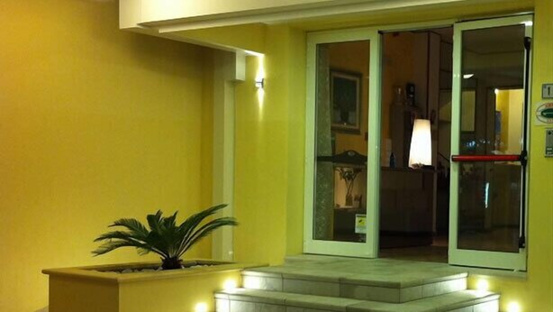 A building entrance with a set of stairs leading up to a door. - Hotel Angela (Misano Adriatico)