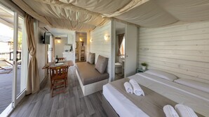 Una habitación acogedora con una cama, un sofá, una mesa de comedor y un televisor.