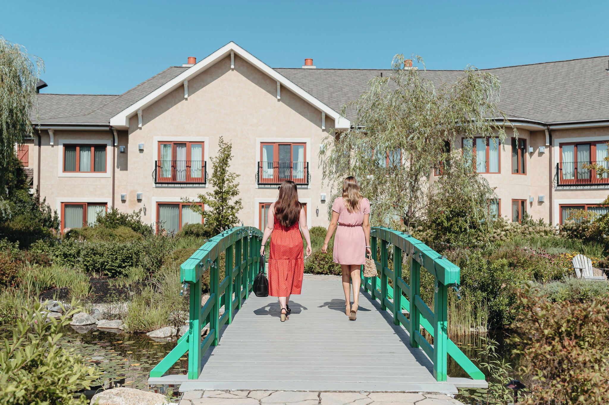 A wooden bridge leading to a building with multiple windows and balconies.