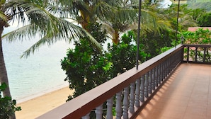 Un balcon avec vue sur la plage et les palmiers.