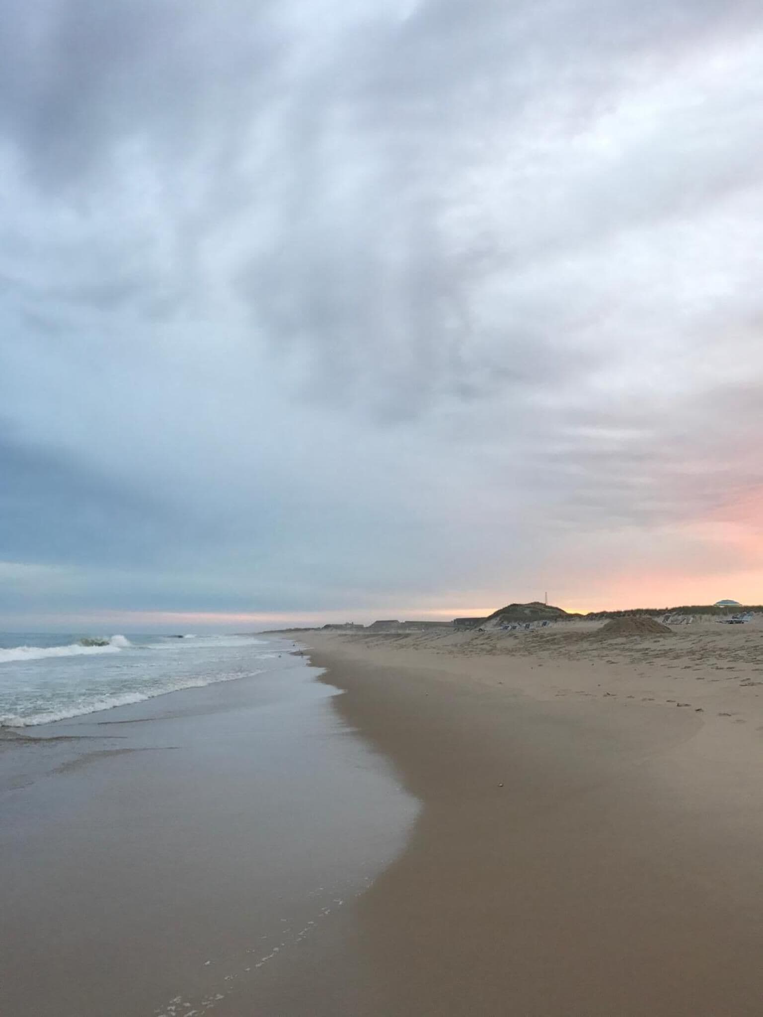 Una platja amb una àmplia riba sorrenca i ones suaus.