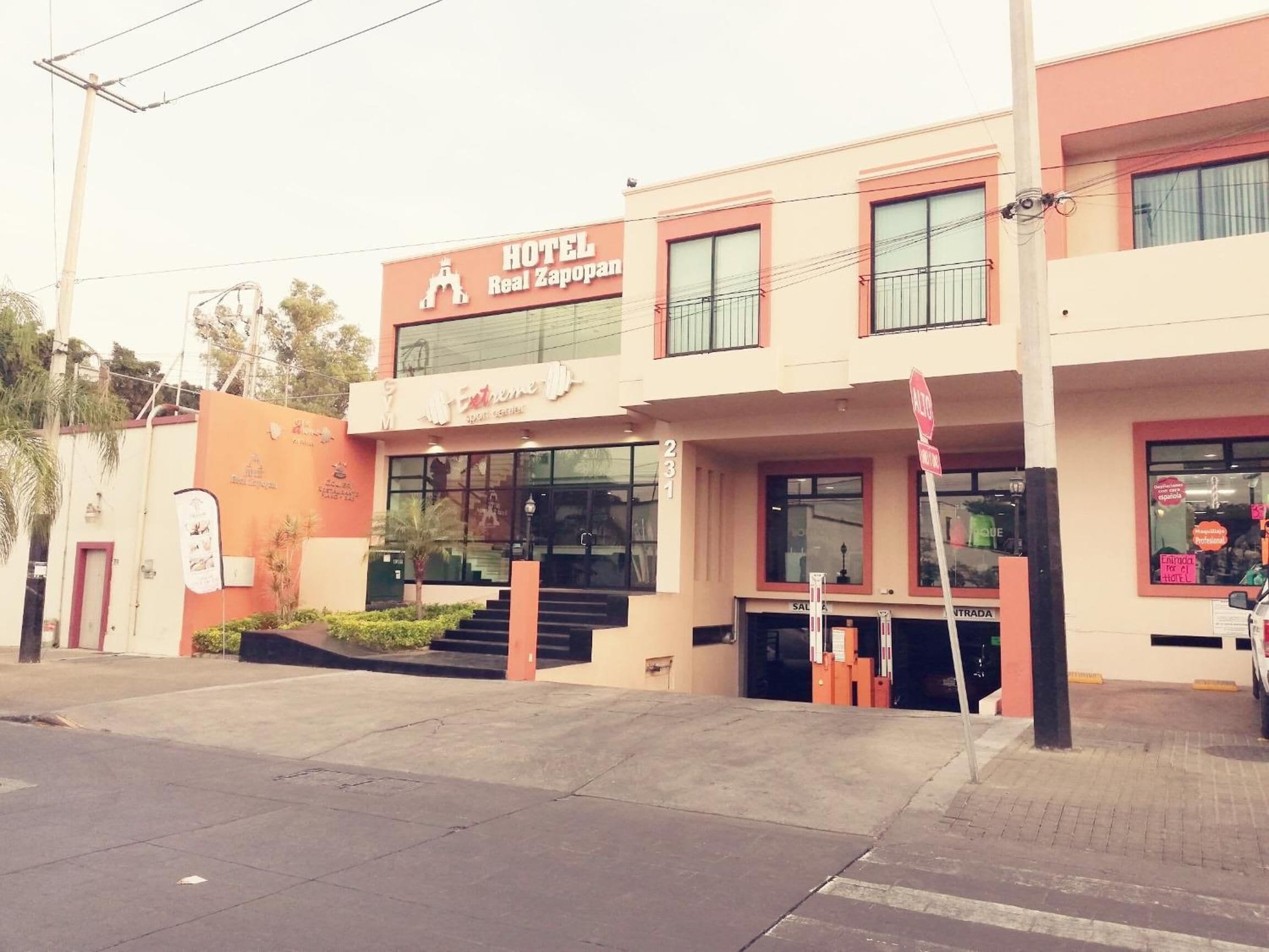 A hotel with a sign reading 'HOTEL Real Zapopan' and a visible entrance with steps leading up to the door.