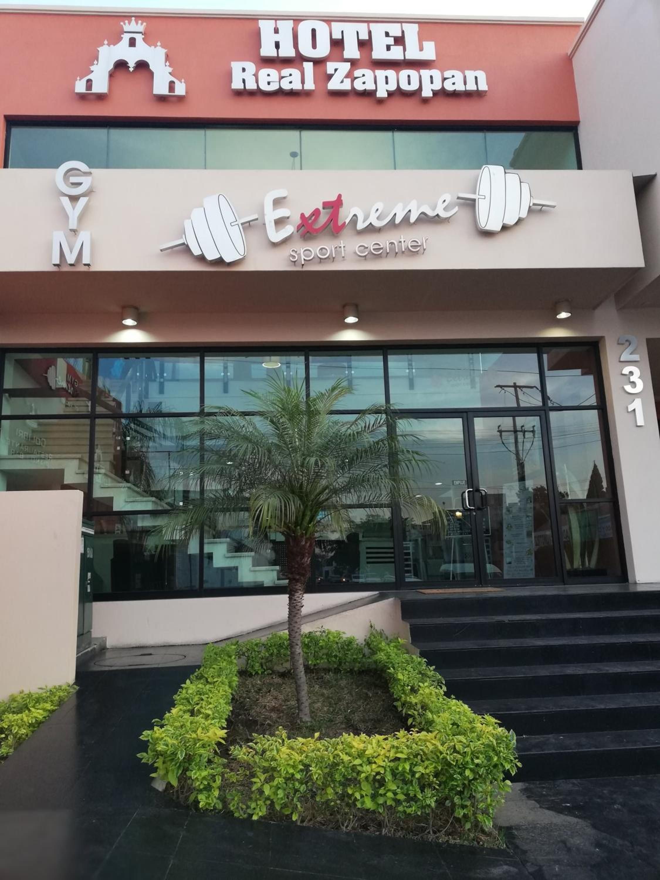 Un hotel llamado 'Real Zapopan' con un letrero que dice 'Centro de Deportes Extremos' debajo.