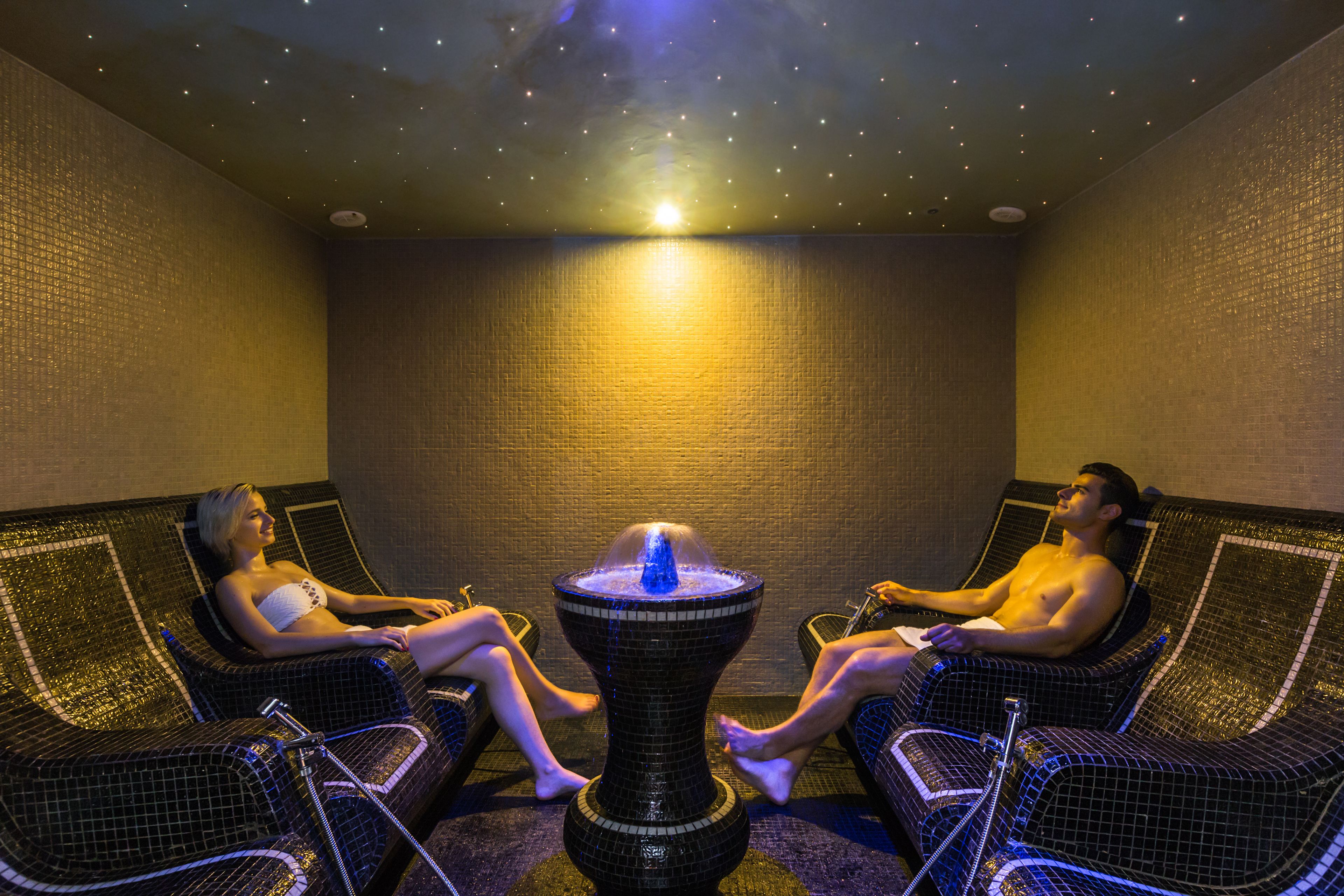 A room with two reclining chairs and a central water feature.