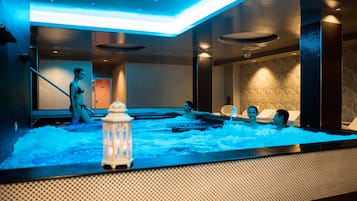 Relax in a serene spa area with a heated water feature and lounge chairs.
