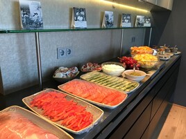 Un bufé con diferentes opciones de comida, como verduras en rodajas, frutas y salsas.