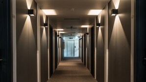 A long, narrow hallway with a carpeted floor and walls lined with doors on both sides. - Hótel Ísafjörður (Isafjordur)