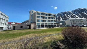 A hotel with a modern design, featuring a flat roof and a large glass facade. - Hótel Ísafjörður (Isafjordur)