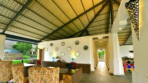 A spacious lobby with a high ceiling, a reception desk, and a view of the outdoors.