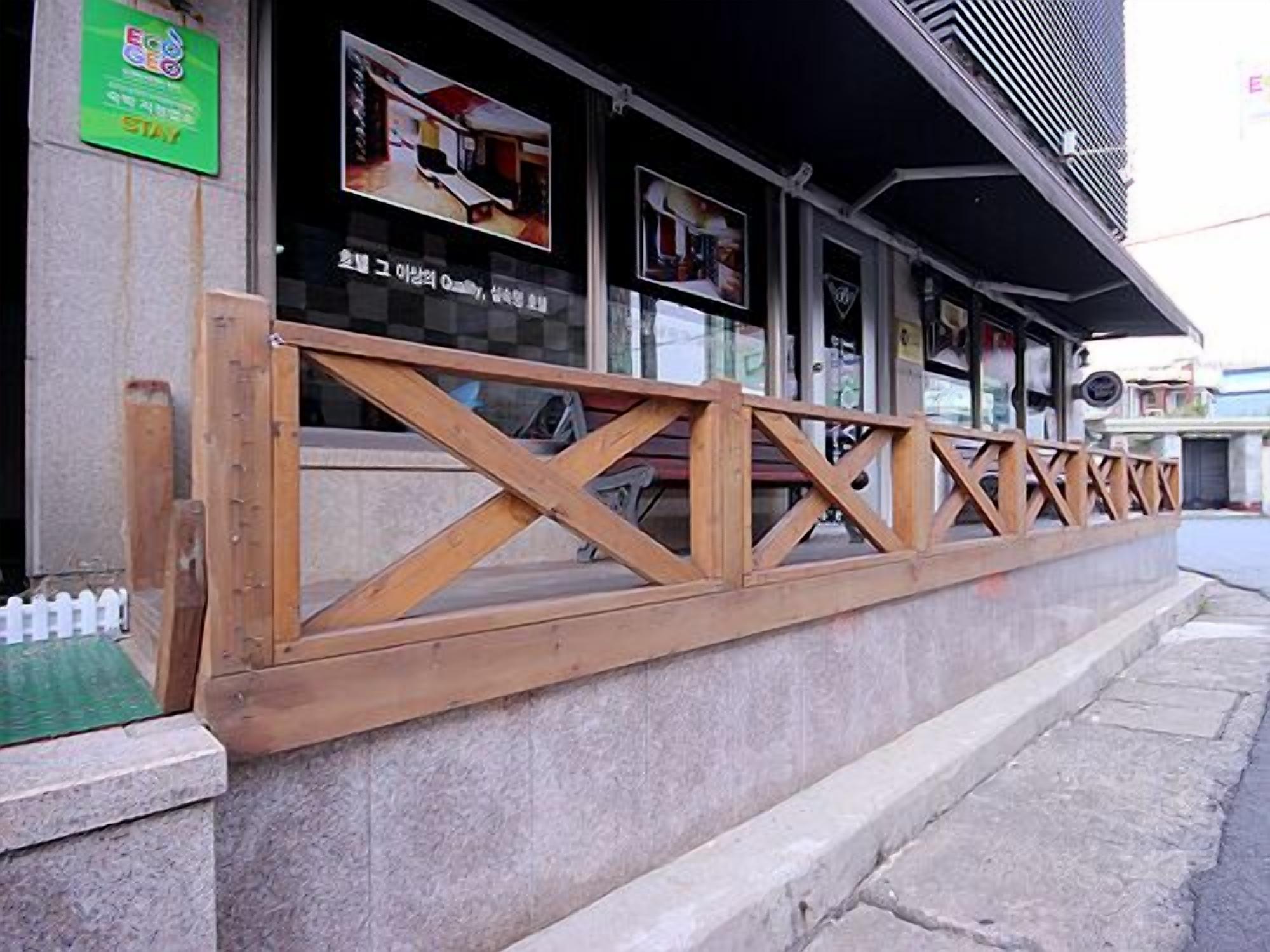 Un restaurante con barandilla de madera y un letrero verde en la pared.