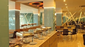 A modern restaurant with a long counter, glass display cases, and black chairs. - Chariot Pattaya Residence (Pattaya)