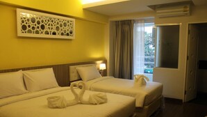 A hotel room with two beds, a decorative wall piece, a window with curtains, and an air conditioning unit. - Chariot Pattaya Residence (Pattaya)