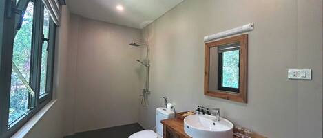Un baño moderno con inodoro, lavamanos y ducha.
