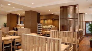 Un intérieur de restaurant moderne, avec des meubles en bois et un espace de sièges central.