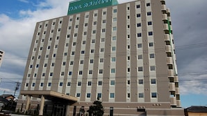Un hôtel à plusieurs étages, reconnaissable à son grand panneau indiquant « HÔTEL ROUTE INN ».