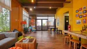 A modern interior with a wooden floor, a sofa, a glass table, and a dining area. - Snooze Too (Brinchang)