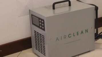 A portable air cleaner labeled "AIRCLEAN" with a control panel and a handle on top.