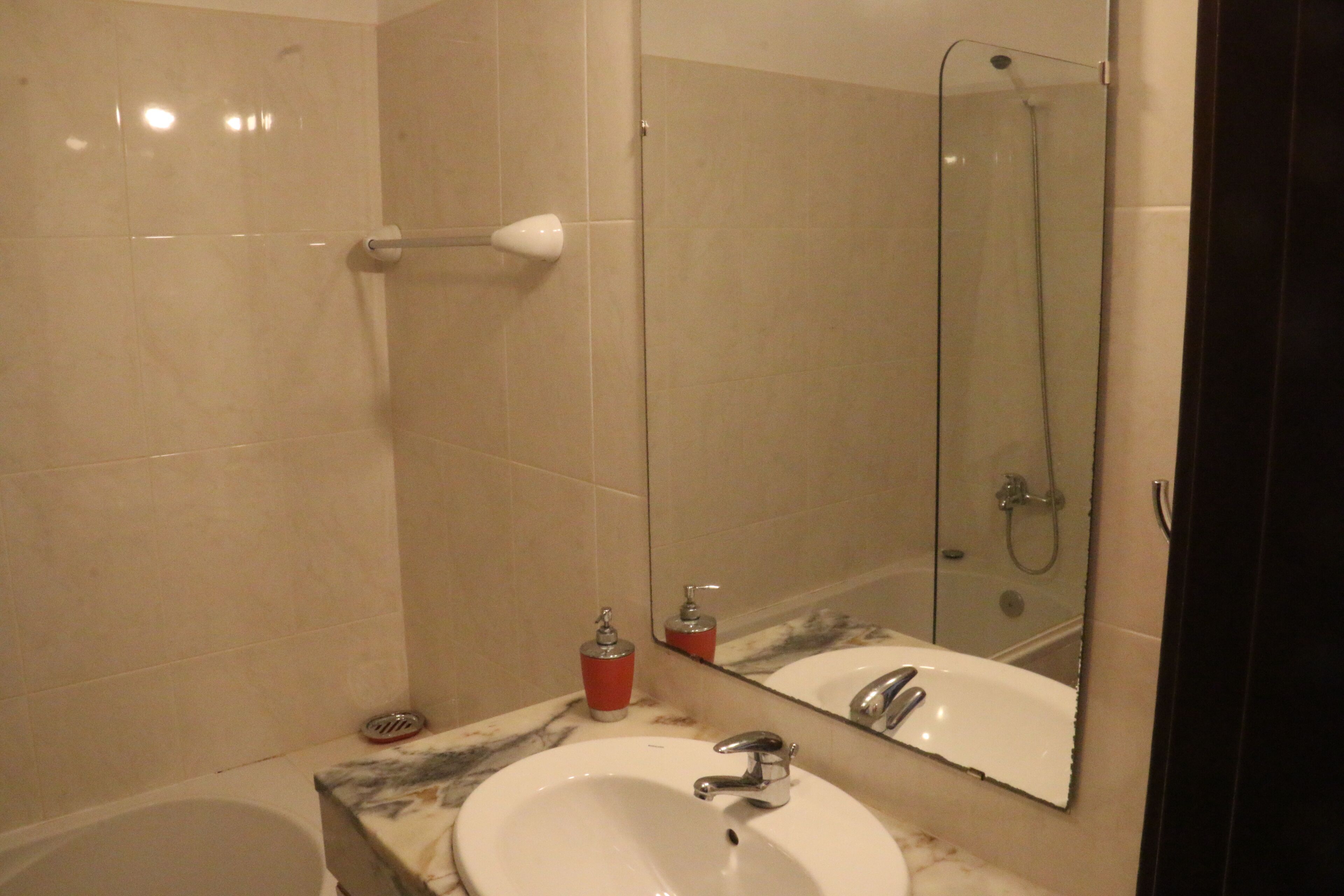Un baño con lavamanos, espejo y ducha.
