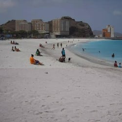 En la playa, playa de arena blanca, camastros y sombrillas