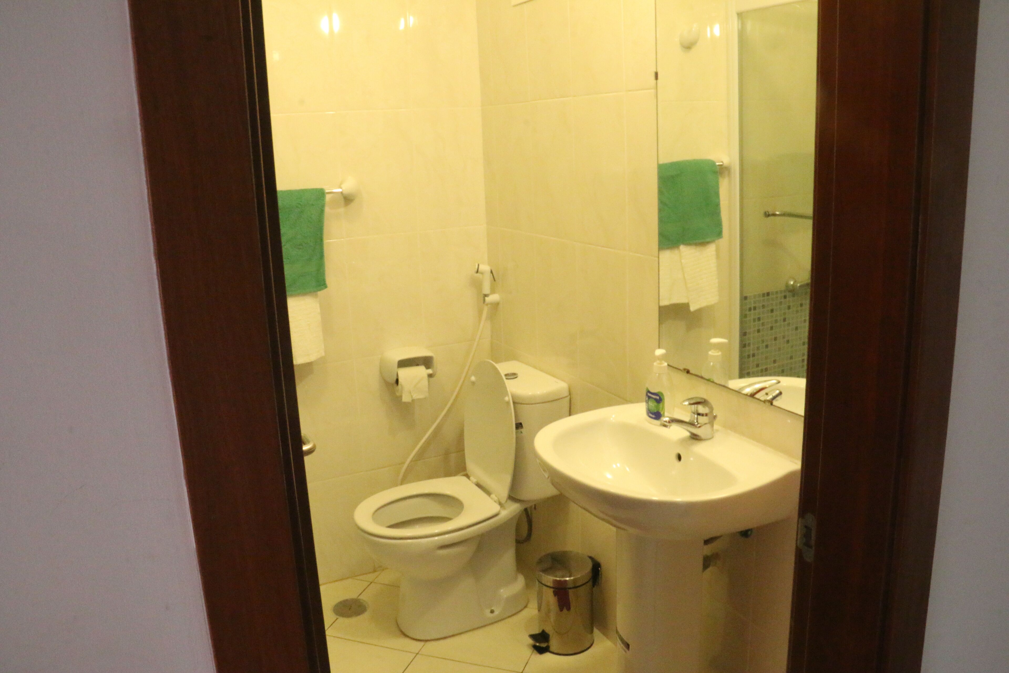 Ein kleines, sauberes Badezimmer mit Toilette, Waschbecken und Spiegel.